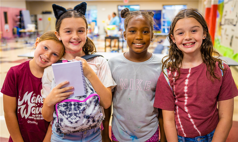 A group of four girls smiles
